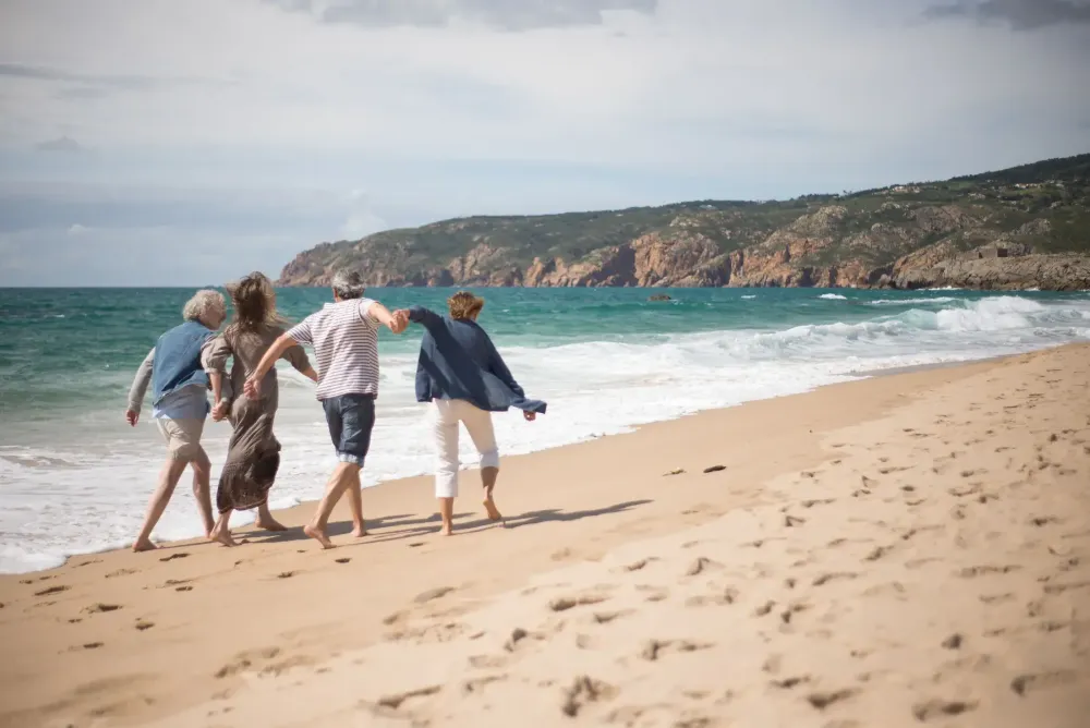 A group of adults walking together along a beach.